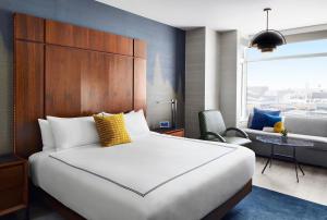 a hotel room with a bed, chair and a window at Gansevoort Meatpacking in New York