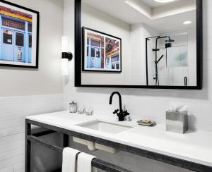 ein weißes Badezimmer mit Waschbecken und Spiegel in der Unterkunft Gansevoort Meatpacking in New York