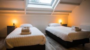 two beds in a room with a window at Welcome in - Oranjezon - Vakantiehuizen 2 & 4 personen in Vrouwenpolder +27 photos