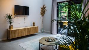 a living room with a tv and a coffee table at Welcome in - Oranjezon - Vakantiehuizen 2 & 4 personen in Vrouwenpolder