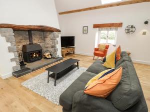 a living room with a couch and a fireplace at The Shippon in Llanrwst