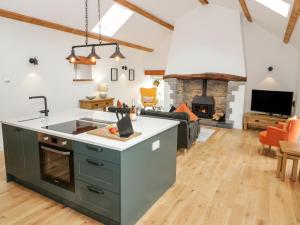 a kitchen and living room with a fireplace at The Shippon in Llanrwst