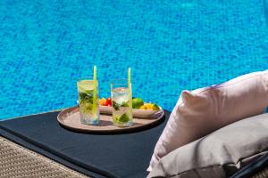 dos bebidas y un plato de fruta en una mesa junto a la piscina en Villa Luigi with a pool, en Cavtat