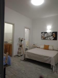 Habitación blanca con cama y espejo en B&B HOUSE BEN en Punta Prosciutto