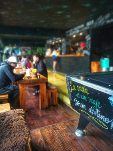 un cartel en un restaurante con gente sentada en una mesa en Moving Hostel Travel Bar en San Carlos de Bariloche