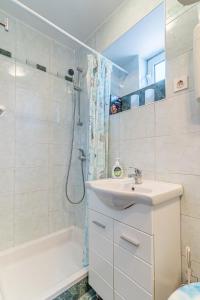 a white bathroom with a sink and a shower at Soba Cres in Cres
