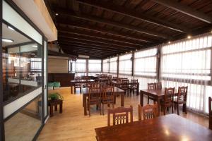 a dining room with tables and chairs and windows at אחוזת האושר in Tiberias