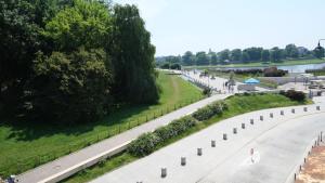 una calle vacía con árboles y una carretera en Bailey Apartment, en Cracovia