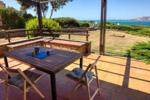 a wooden table and two chairs on a patio at SulMare Apartment in Stintino
