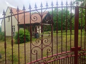 a iron fence with a house in the background at Maison de caractère à Mouterre-Silly avec grand jardin in Mouterre-Silly +6 photos