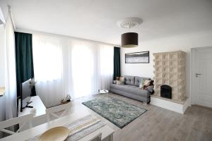sala de estar con sofá y chimenea en Best Apartman Lelle en Balatonlelle