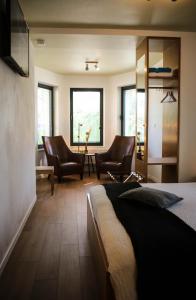 een slaapkamer met 2 stoelen en een bed in een kamer bij Hotel Gasthof Kapelhof in Erpe-Mere
