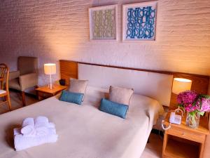 a bedroom with a large white bed with two pillows at Cariló Paradise Apart Hotel & Spa in Carilo +61 photos