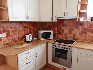 cocina con armarios blancos y microondas en Holiday Home Dekany - FOD151 by Interhome, en Balatonfenyves