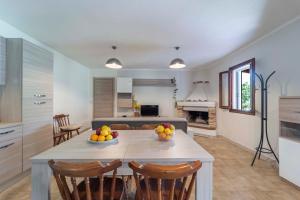アルゲーロにあるOpen space accommodationのキッチン、リビングルーム(フルーツを用意したテーブル付)