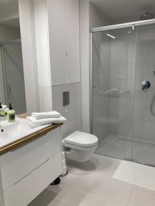 a white bathroom with a shower and a toilet at Rogowo Pearl Apartament Resko in Rogowo