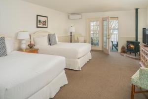 a bedroom with two beds and a fireplace at Spruce Point Inn Resort and Spa in Boothbay Harbor