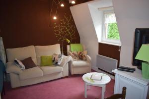 a living room with a couch and a chair at Les Locations de Stéphanie Les Hautes Vosges in Sondernach