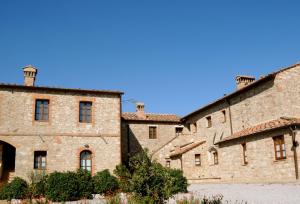 un ancien bâtiment en pierre avec un ciel bleu en arrière-plan dans l'établissement Borgo Beccanella, à Asciano