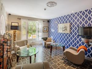 una sala de estar con paredes estampadas en azul y blanco en Hôtel La Suite, en Villeneuve-lès-Avignon