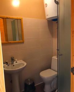 a bathroom with a sink and a toilet and a mirror at Hotel Comfort in Vapnyarka