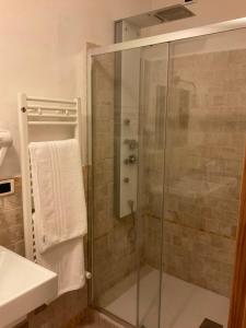 y baño con ducha acristalada y lavamanos. en Guest House B&B Pietra Bianca, en Ostuni