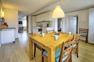 a dining room and kitchen with a wooden table and chairs at fewo1846 - Landliebe - idyllisch gelegene Wohnung mit 2 Schlafzimmern und Garten in Husby