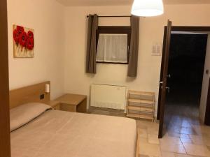 a bedroom with a bed and a window and a door at Guest House B&B Pietra Bianca in Ostuni