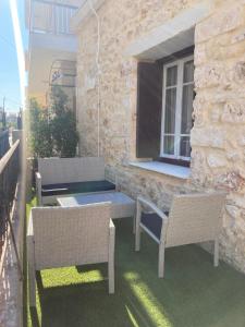 a patio with two chairs and a table and a window at Reina House in Chania