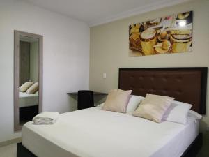 ein Schlafzimmer mit einem großen weißen Bett in einem Zimmer in der Unterkunft Escala Hotel in Valledupar