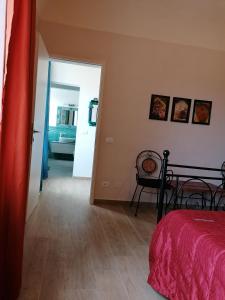 - une chambre avec un lit et une porte menant à une salle de bains dans l'établissement Casa Mosaico, à Volterra