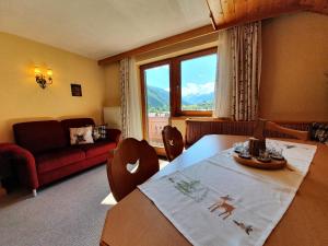 a living room with a table and a couch at Gaestehaus Tirolergruss in Pettneu am Arlberg