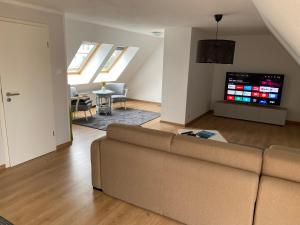 a living room with a couch and a tv at Henning 2 in Kirchdorf