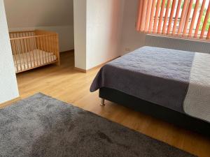 a bedroom with a bed and a crib and a window at Henning 2 in Kirchdorf
