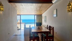 a dining room with a table and a view of the ocean at Albufeira, One step to the beach (13) in Albufeira