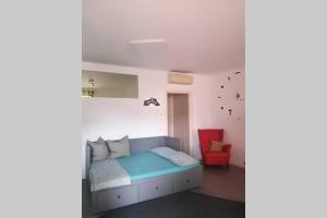 una camera con letto e sedia rossa di La Casetta, appartamento nel verde a Sommacampagna a Sommacampagna