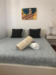 a bed with a towel shaped like a dog on it at CC Bay House in Costa da Caparica