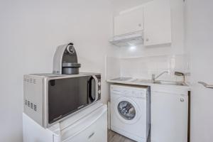 uma cozinha com uma máquina de lavar roupa e uma máquina de lavar e secar roupa em Le Petit Normand em Courseulles-sur-Mer