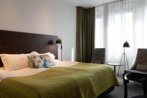 um quarto de hotel com uma cama e uma cadeira em Elite Hotel Ideon, Lund em Lund