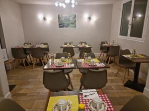 a restaurant with tables and chairs in a room at Hotel du Haut Marais in Saint-Marcel