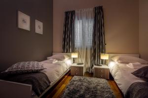 2 łóżka pojedyncze w pokoju z oknem w obiekcie Apartment Maris w Rovinj