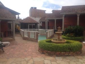 un patio con una fuente frente a algunas casas en Hotel Aguablanca, en La Mesa
