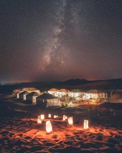 a starry night with a group of tents in the desert at Sahara Majestic Luxury Camp in Merzouga