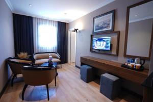 a living room with a couch and a flat screen tv at Mineo Hotel Taksim in Istanbul