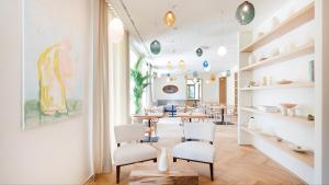 a dining room with white chairs and a table at BASKE VILLA in Martinske Hole