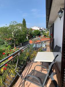 a table and chairs on a balcony with flowers at Draga Rooms in Njivice