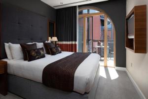 a bedroom with a large bed and a balcony at The Chambers in Leeds