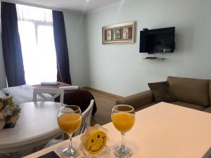 Orbi Sun&Sea Apartment في باتومي: غرفة معيشة مع كأسين من عصير البرتقال على طاولة
