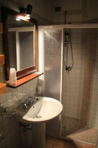 y baño con lavabo y ducha. en Guerrin Meschino, en Montemonaco