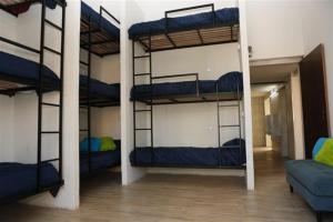 a room with three bunk beds and a couch at Real Ros Hostel in Rosario